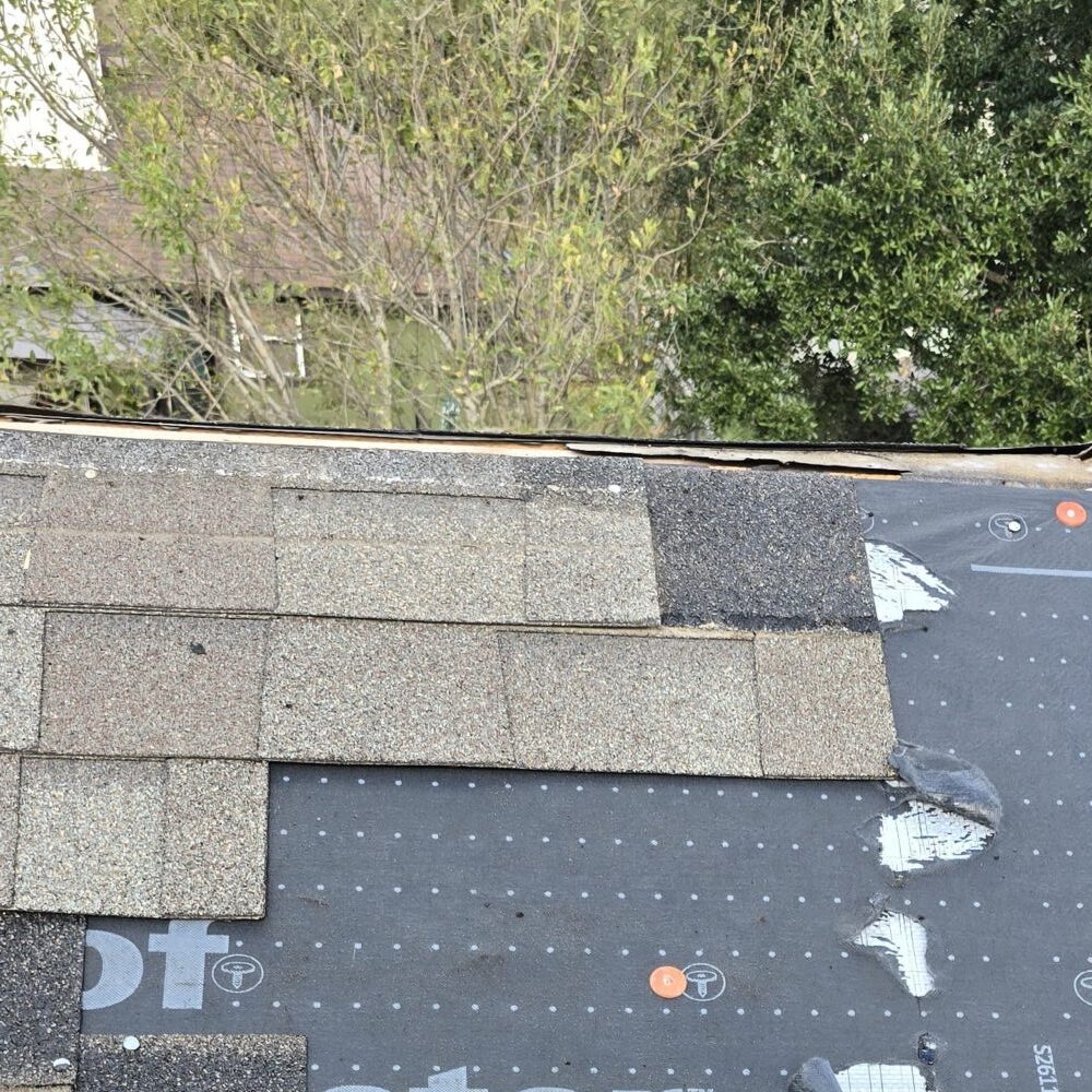 Roof edge repair with underlayment exposed and shingles partially installed near the eave.
