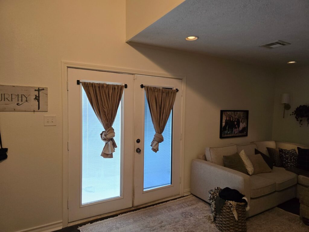 Living room with French doors, curtains, and a sectional sofa