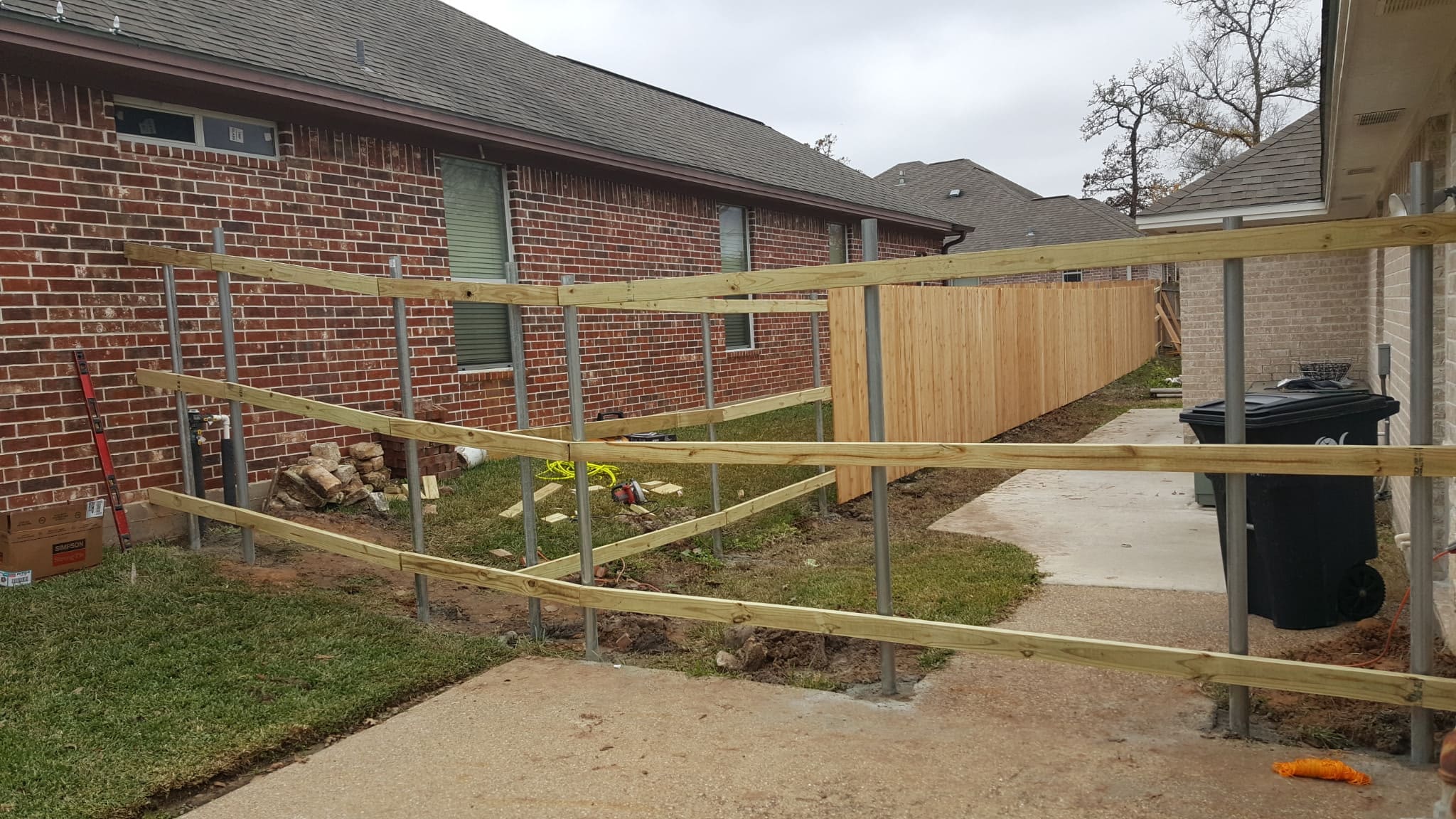 cedar fence installation with gate near driveway in Navasota Texas