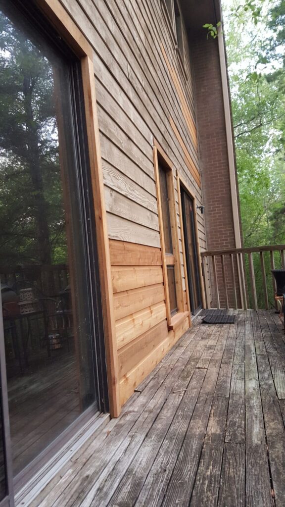 Entry door with curtain and interior wall space near staircase railing