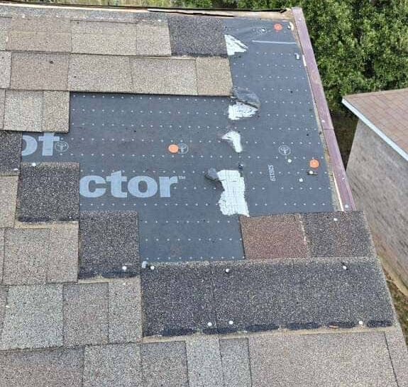 Roof underlayment installed with partial asphalt shingles during roof replacement work.