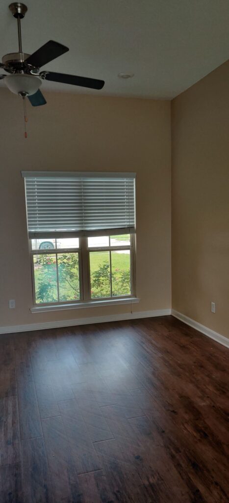 Exterior wall covered with black weather barrier next to a brick corner