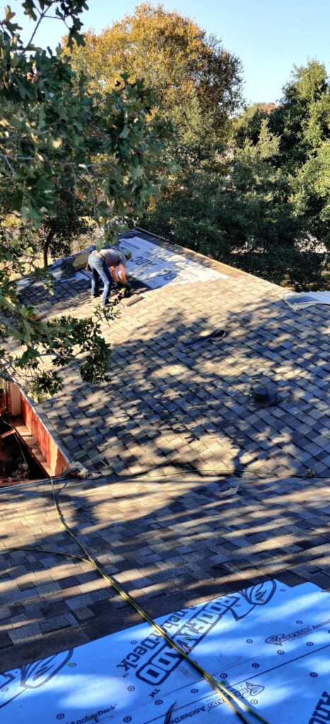 Roofer installing ridge vent on shingle roof in Caldwell Texas