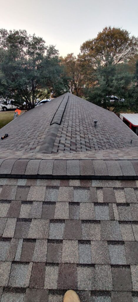 Asphalt shingle roof ridge installed during roofing project in Navasota, Texas.