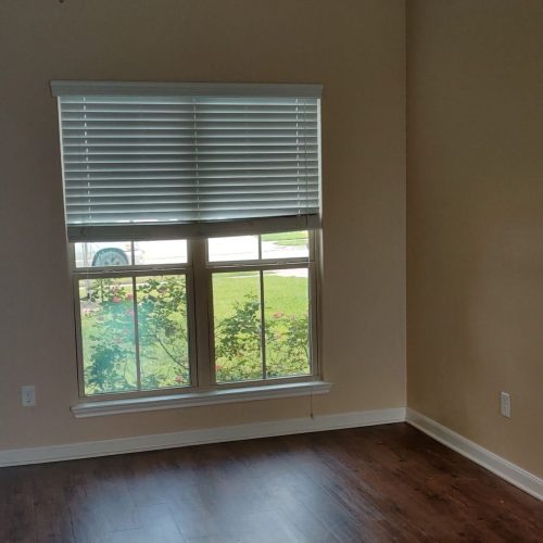 Exterior wall covered with black weather barrier next to a brick corner